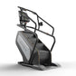 Matrix Performance ClimbMill with black frame, gray base, digital display console, and stair-stepping pedals on white backgro