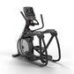 Black and gray Matrix elliptical machine with digital display console, handlebar grips, and foot pedals on white background