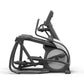 Black and gray elliptical exercise machine with suspended footrests and digital console on white background