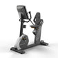 Matrix Performance Hybrid Cycle, black and gray upright exercise bike with digital display and padded seat, on white backgrou