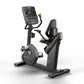 Black Matrix recumbent exercise bike with digital console display, foot pedals, and cushioned seat on white background