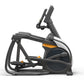 Black and orange elliptical trainer with upright display console and footplate pedals on white background