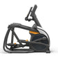 Black and charcoal elliptical trainer with orange accents, digital display console, and foot pedals on white background