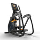 Black and orange elliptical trainer with digital display console, orange foot pedals, and stationary handlebars on white back