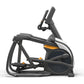 Black and gray elliptical trainer with orange accents, digital display console, and foot pedals on white background