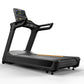 Black and gray commercial treadmill with digital display console, dual handles, and orange accent stripe on belt