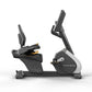 Matrix Performance recumbent exercise bike with gray and black frame, adjustable seat, digital display console, and gold acce