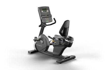 Matrix black recumbent exercise bike with digital console displaying metrics, padded seat, and stationary pedals on white bac