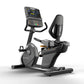 Matrix black recumbent exercise bike with digital touchscreen display, padded seat, and attached backrest on white background