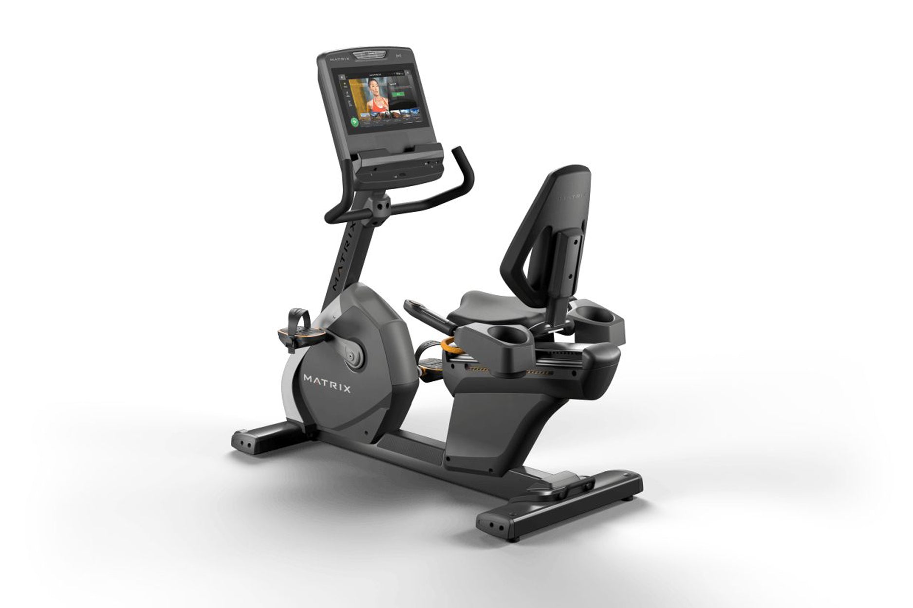 Black and gray Matrix recumbent exercise bike with digital display screen, padded seat, and foot pedals on white background