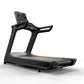Black commercial treadmill with digital display console, orange accent stripe, and dual handrails on white background
