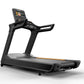 Black commercial treadmill with digital touchscreen display, handrails, and gray running deck with orange accent stripe on wh