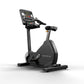 Matrix black upright exercise bike with digital console, black seat, and foot pedals on white background