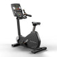 Matrix black upright exercise bike with digital display console showing time and metrics, handlebars, and seat on white backg