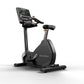 Matrix black upright exercise bike with digital console, black seat, and pedals on white background