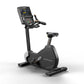 Matrix Performance upright exercise bike with digital display screen, black frame, padded seat, and handlebars, on white back