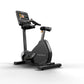 Black Matrix upright stationary bike with digital touchscreen display and gold accents, on white background