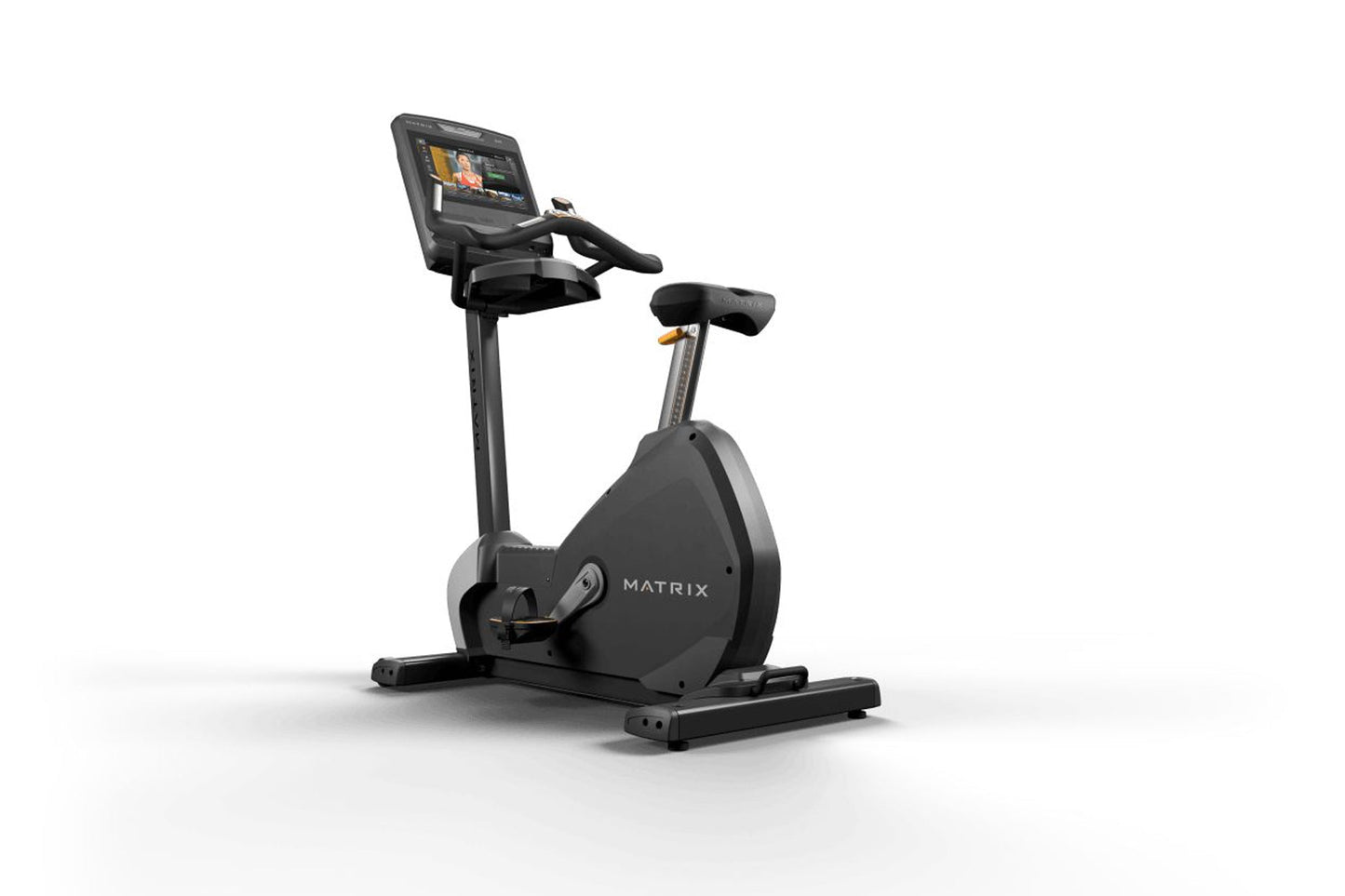 Black Matrix upright stationary bike with digital touchscreen display and gold accents, on white background