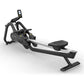 Black and silver Matrix rowing machine with digital console, footplate, and ergonomic handles on white background