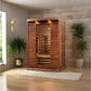 Two-person infrared sauna with cedar wood construction, glass door, and digital control panel in modern spa room with potted 