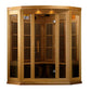 Natural wood corner infrared sauna with glass doors, vertical slat vents, interior bench seating, and overhead lighting on wh