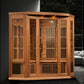 Cedar wood corner sauna with glass doors, vertical slat panels, and louvered vents in modern interior setting
