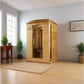 Natural cedar wood infrared sauna cabin with glass door and interior heaters, shown in modern bedroom setting