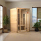 Natural wood corner sauna with glass doors and black interior heating panels in modern room setting