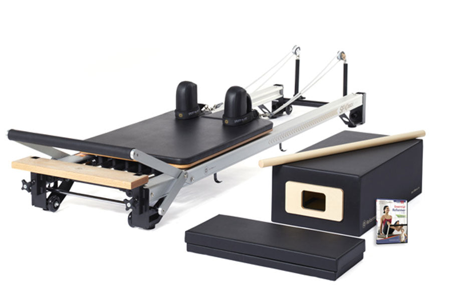 Merrithew SPX Home Pilates Reformer with black platform, wooden footbar, dual black domes, white frame, and included accessor