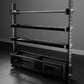 Black metal storage rack with four horizontal shelves and perforated base, adjustable arms on steel uprights