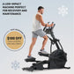 Man using black elliptical machine with handlebar controls, wearing white tank top and gray shorts, on light blue background
