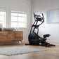Black elliptical machine with dual handles and digital display in home gym setting