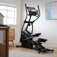 Black elliptical machine with digital screen and dual handles in modern living room setting