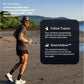 Male runner jogging on beach in dark shirt and shorts, wearing sunglasses and cap, with mountains and water in background, pr