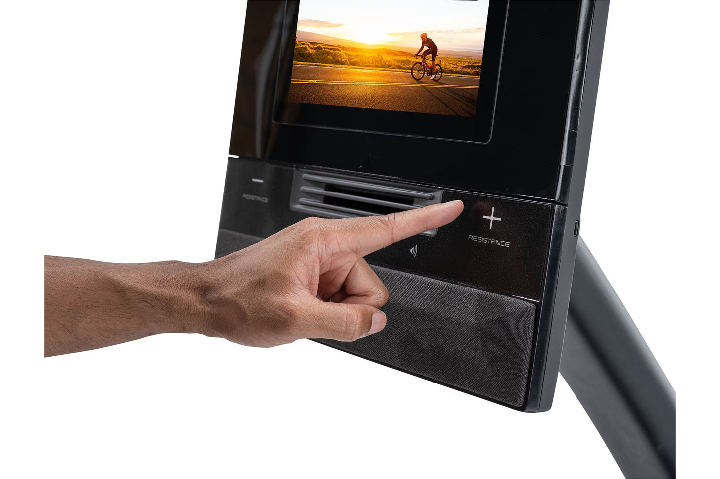 Hand touching touchscreen display on black NordicTrack recumbent exercise bike showing cyclist at sunset