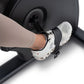 Foot on white and black sneaker on NordicTrack recumbent exercise bike pedal, worn by model in beige leggings