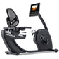 NordicTrack recumbent exercise bike with black mesh seat, curved footrest, dual handlebars, and digital display monitor mount