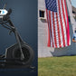 Black NordicTrack elliptical machine with handlebar and foot pedals on blue background, next to runner in blue shirt jogging 