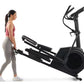 Woman in pink tank top and gray leggings using black NordicTrack AirGlide 7i elliptical with dual handles and large wheel on 
