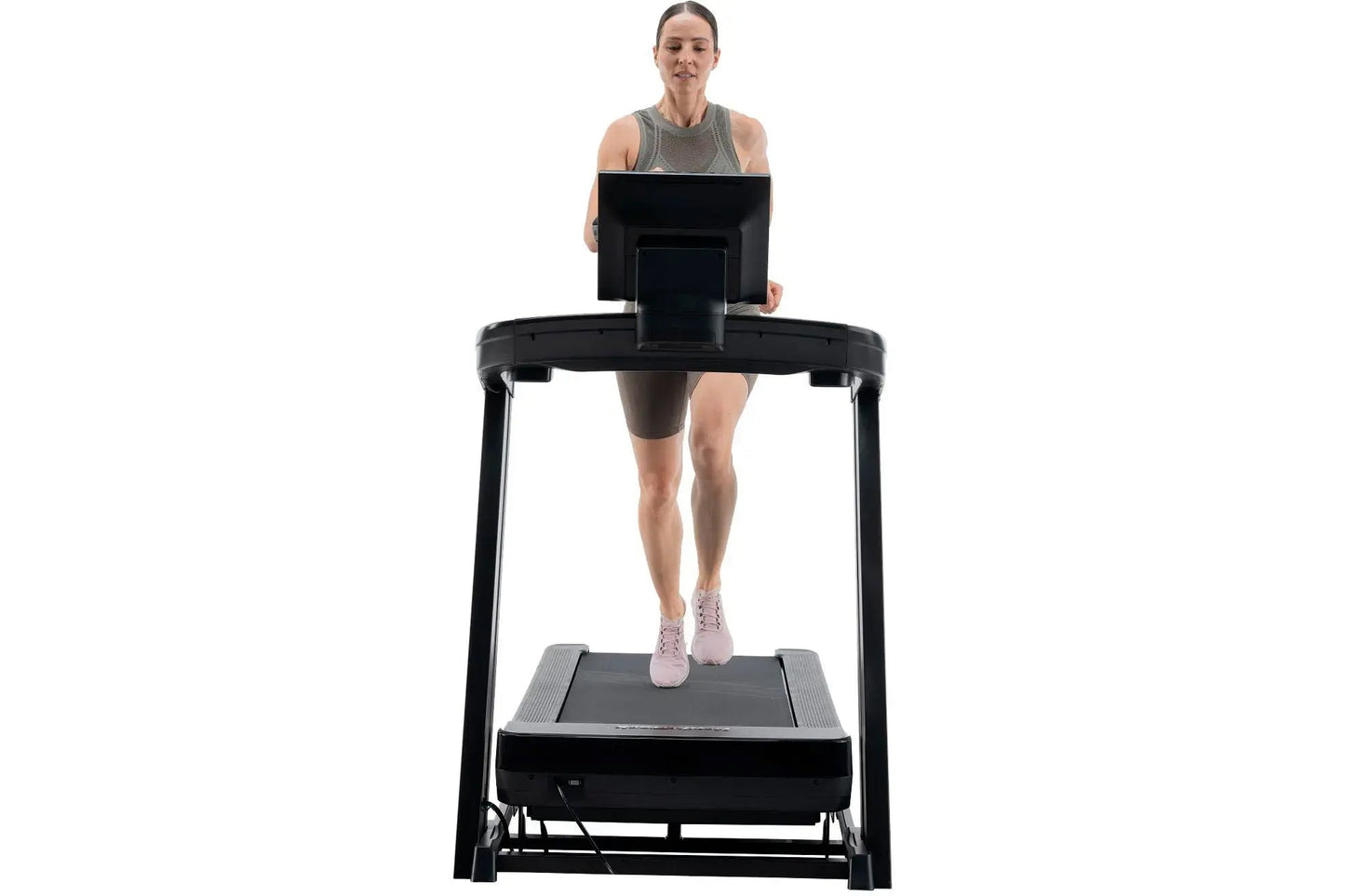 Woman wearing gray tank top and brown shorts running on black NordicTrack treadmill with digital display, shown from front on