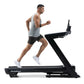 Man running on NordicTrack Commercial 1750 black treadmill, wearing light gray sleeveless tank top and black shorts