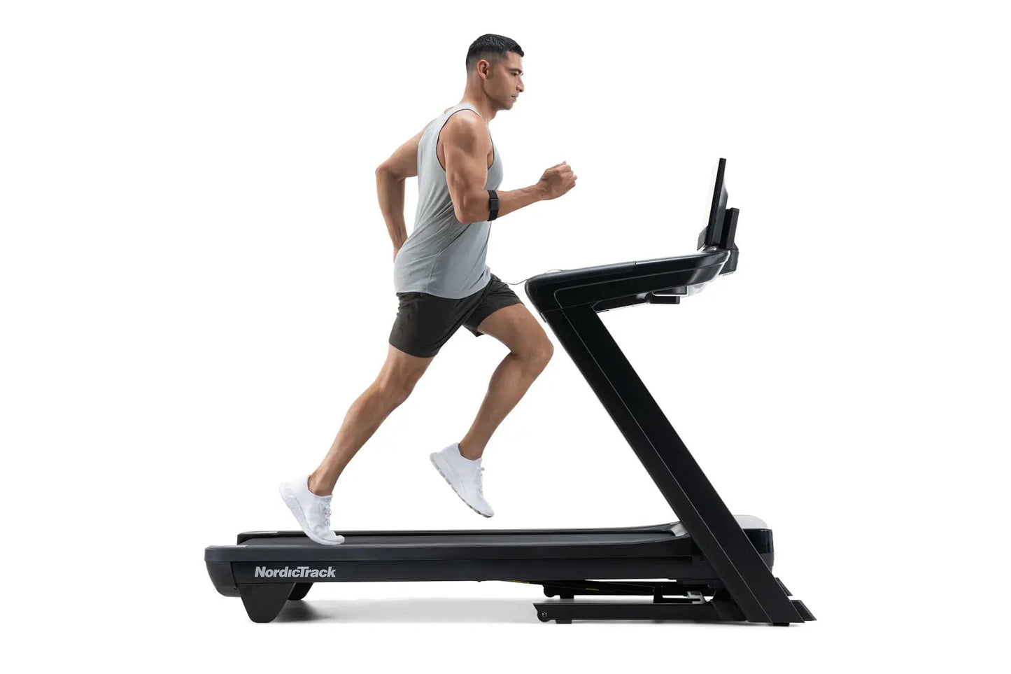 Man running on NordicTrack Commercial 1750 black treadmill, wearing light gray sleeveless tank top and black shorts