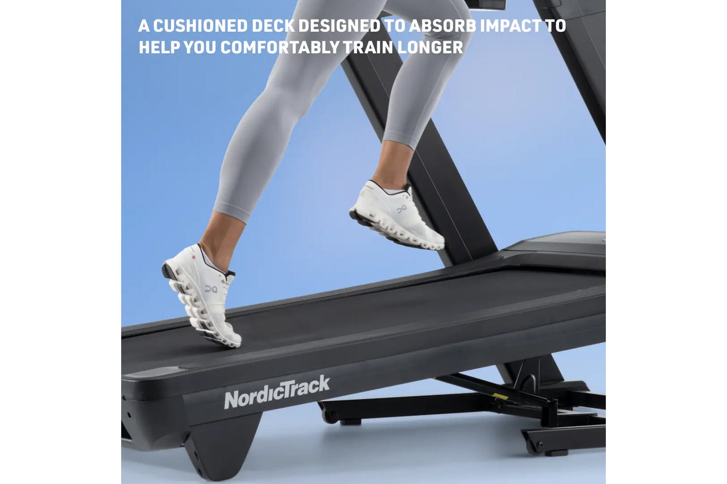 Person wearing white running shoes and gray leggings running on NordicTrack treadmill with cushioned black deck against blue 