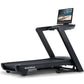 Black NordicTrack Commercial 2450 treadmill with integrated tablet display showing fitness video on white background
