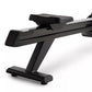 Black stationary rowing machine with padded seat, foot pedals, and horizontal resistance rail on white background