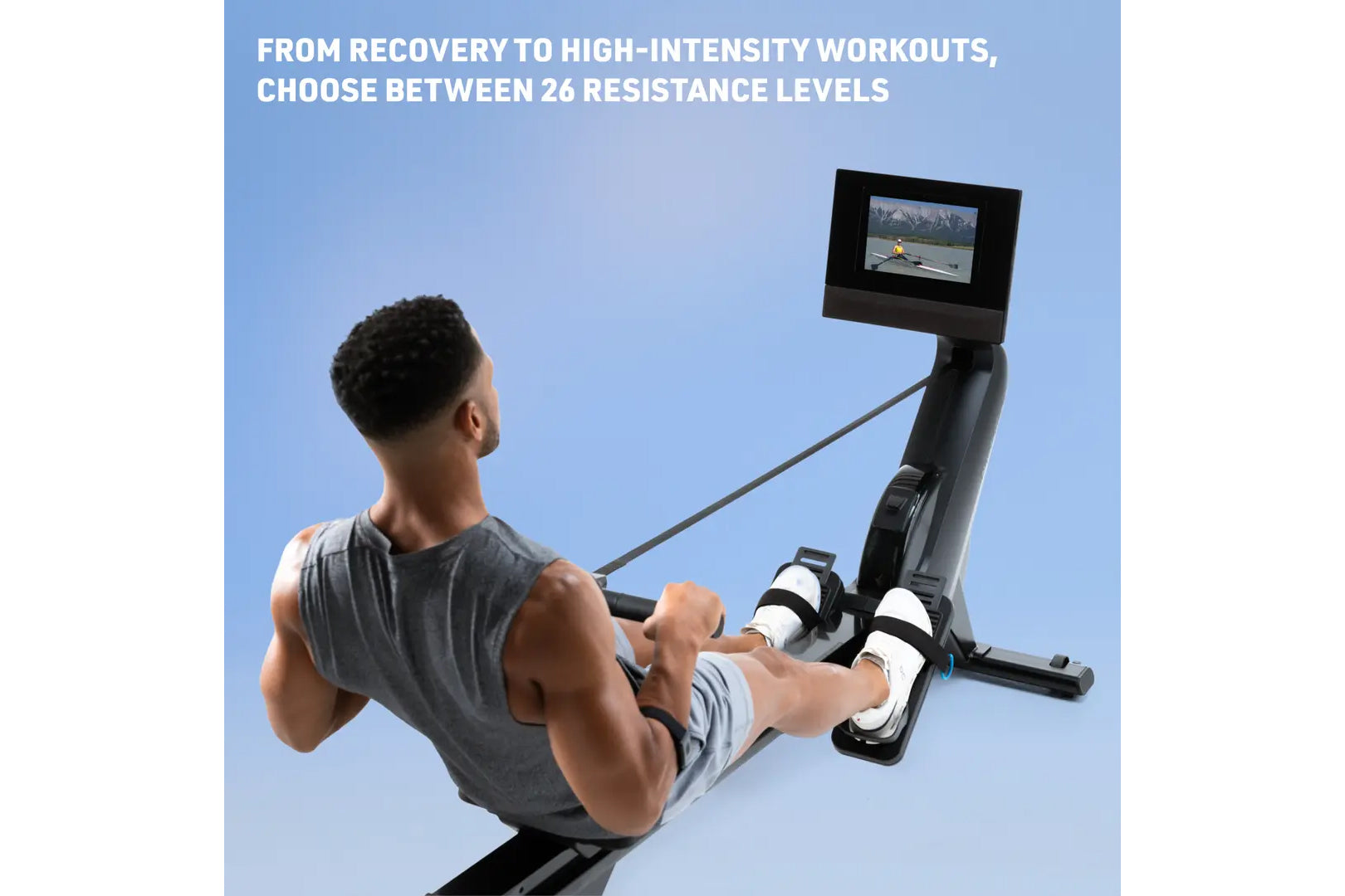 Man using black NordicTrack rowing machine with digital display showing workout video, on blue background