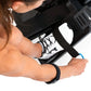 Person's hands gripping black rower footrest with white and black athletic shoe on pedal