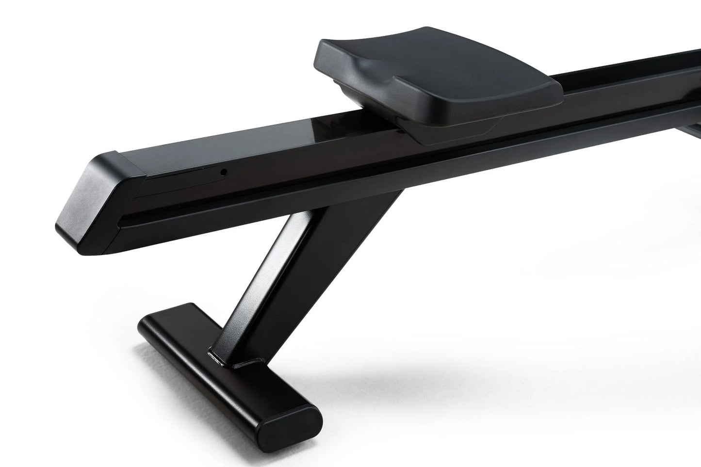 Black NordicTrack RW700 rowing machine with padded seat and angled footrest on white background