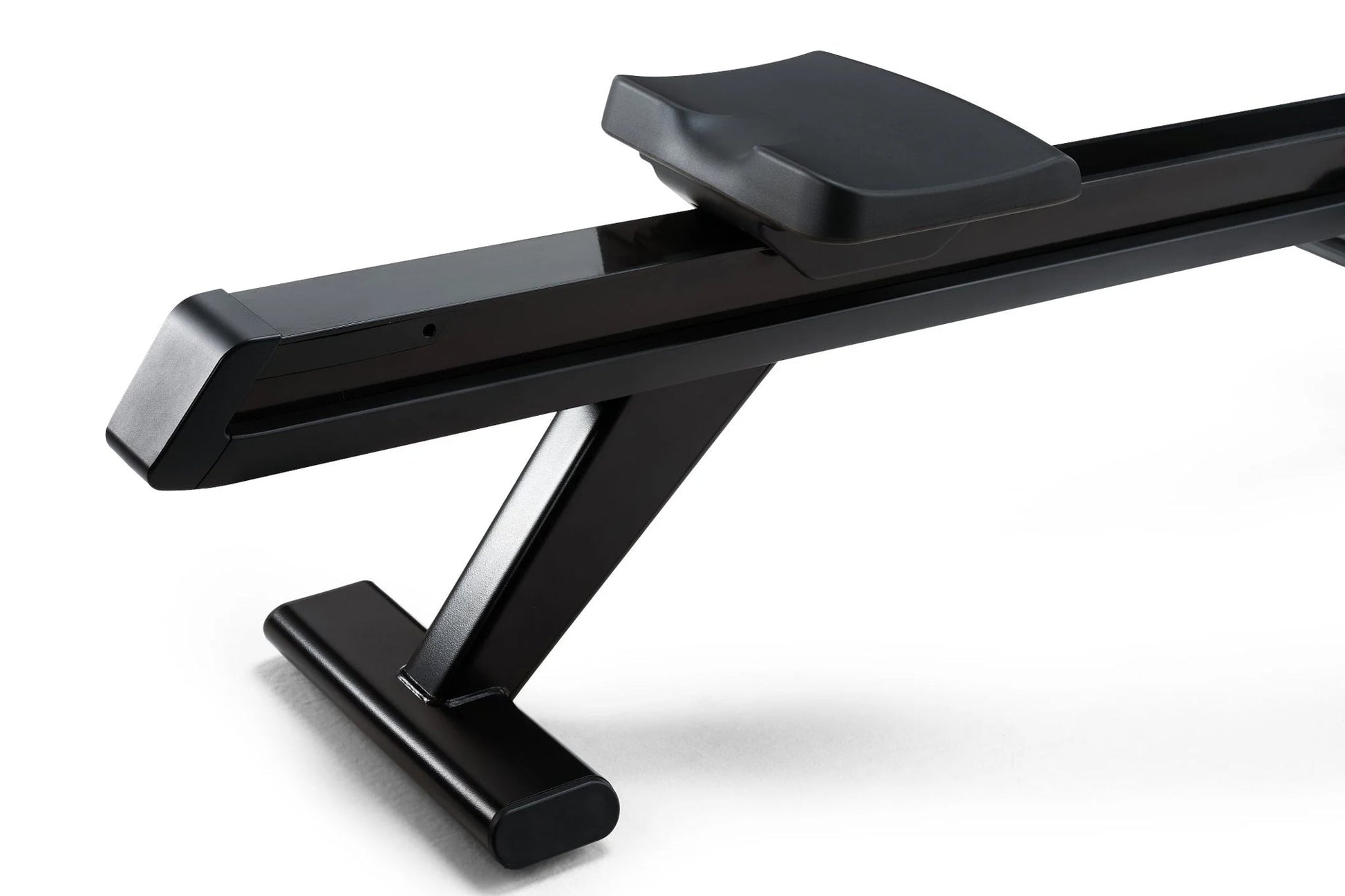 Black NordicTrack RW700 rowing machine with padded seat and angled footrest on white background