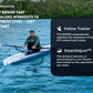 Man in gray shirt rowing on white and teal rowing machine in blue ocean water, with forested shoreline in background